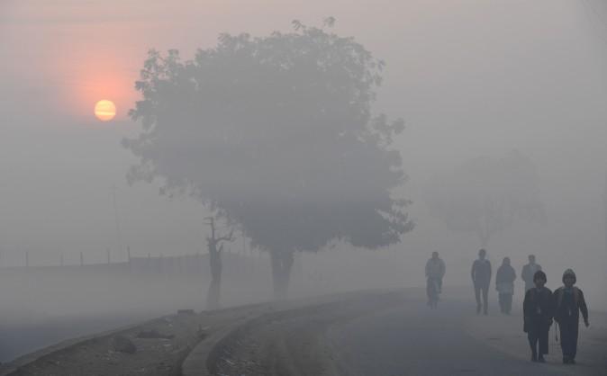 The sun rises as children walk to school on a cold foggy morning on the outskirts of New Delhi on Feb. 2, 2017. (Prakash Singh/AFP/Getty Images)