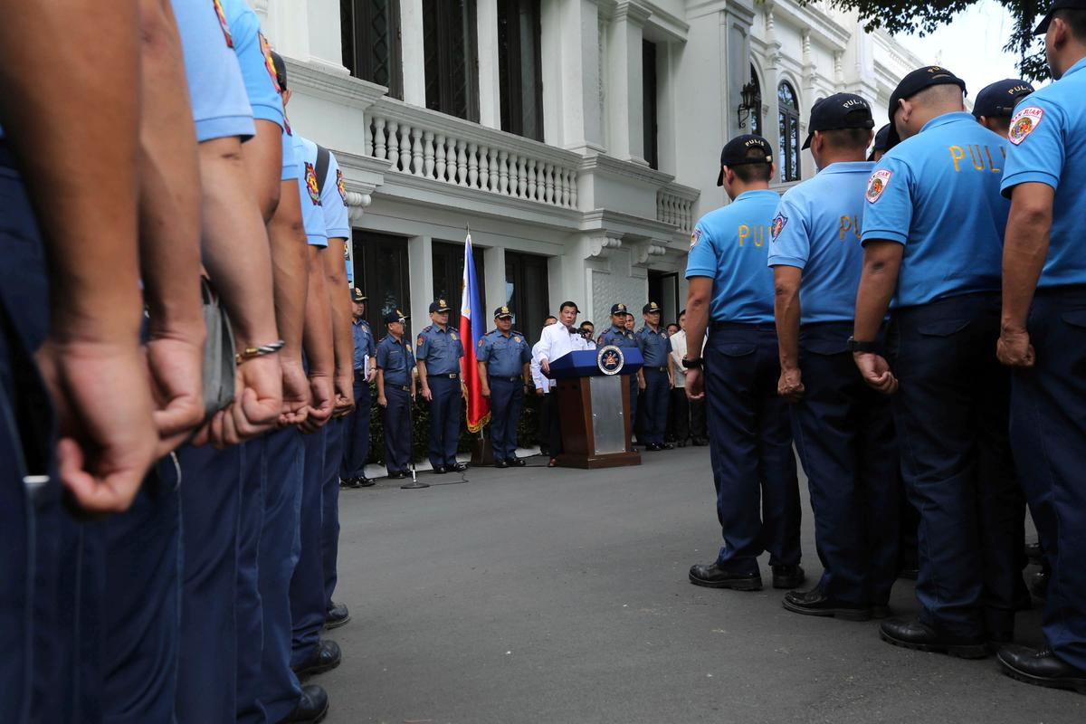 Philippine President Rodrigo Duterte (C) by the podium, speaks to erring policemen during an audience at the Presidential Palace grounds in Manila, Philippines on Feb. 9, 2017. (King Rodriguez/Presidential Photographers Division, Malacanang Palace via AP)