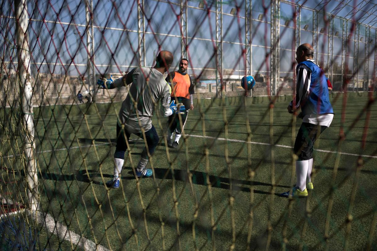 Mosul residents play soccer on a pitch in the liberated eastern part of the city on Feb. 8, 2017. (AP Photo/Bram Janssen)