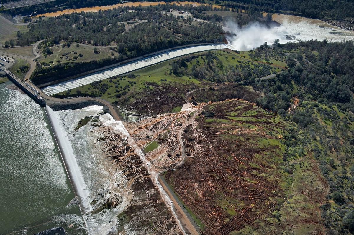 Lake water flows over the emergency spillway, bottom left, at Lake Oroville for the first time in the nearly 50-year history of the Oroville Dam in Oroville, Calif., on Feb. 11, 2017. (Randy Pench/The Sacramento Bee via AP)