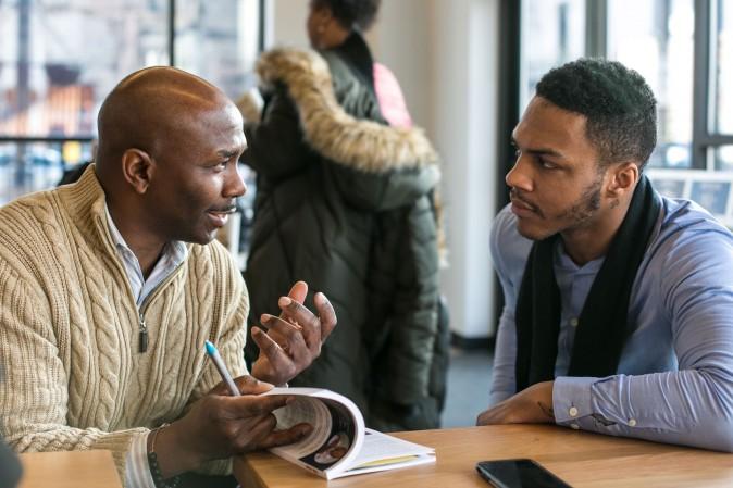 Dwayne Bryant, author of "The Stop," a book on police-community relations, talks with former gang member Deandre Robertson at a new Chipotle in Englewood, Chicago, on Feb. 1, 2017. (Benjamin Chasteen/Epoch Times)