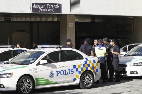 Police officers wait at the forensic department entrance at a hospital in Putrajaya, Malaysia on on Feb. 15, 2017. (AP Photo/Daniel Chan)