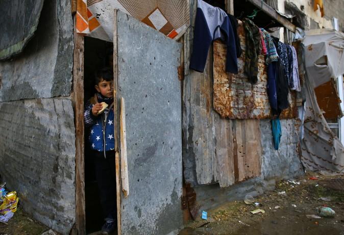 A Palestinian boy stands at the entrance of his family's impoverished house near the ruins of a building in Beit Hanun in the northern Gaza Strip on Feb. 15, 2017. (MOHAMMED ABED/AFP/Getty Images)