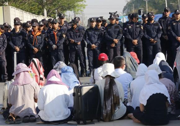 Buddhist pray in front of policemen outside the Wat Dhammakaya temple in Pathum Thani province, Thailand, on Feb. 16, 2017. (AP Photo/Sakchai Lalit)