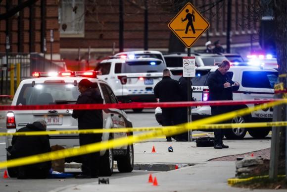 Crime scene investigators collect evidence from a scene where Abdul Razak Ali Artan rammed his Honda Civic into a crowd of people and then took out a knife and slashed 13 people on the campus of Ohio State University in Columbus on Nov. 28, 2016. (AP Photo/John Minchillo)