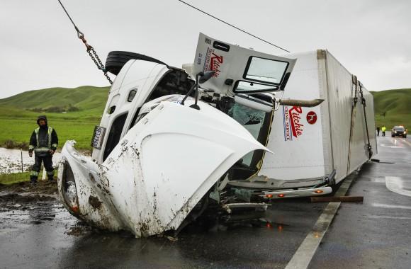 A crew from Johnboy's Towing uprights a big rig that was overturned by high winds at the Highway 46 and 41 interchange in Cholame, Calif., Friday, Feb. 17, 2017. (Joe Johnston/The Tribune (of San Luis Obispo)