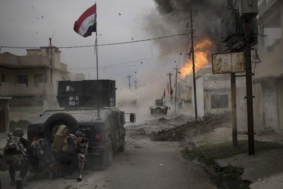 A car bomb explodes next to Iraqi special forces armored vehicles as they advance towards Islamic State held territory in Mosul, Iraq on Nov. 16, 2016. Troops have established a foothold in the city's east from where they are driving northward into the Tahrir neighborhood. The families in Tahrir are leaving their homes to flee the fighting. (AP Photo/Felipe Dana, File)