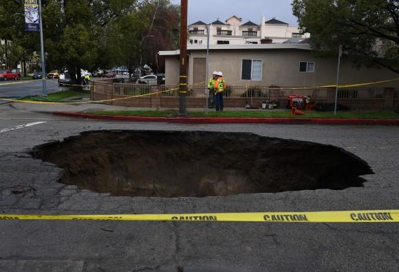 A 20-foot sinkhole that swallowed two vehicles in North Laurel Canyon Blvd, in Los Angeles, is cordoned-off on Feb. 18, after a powerful storm hit Southern California. (Mark Ralston/AFP/Getty Images)