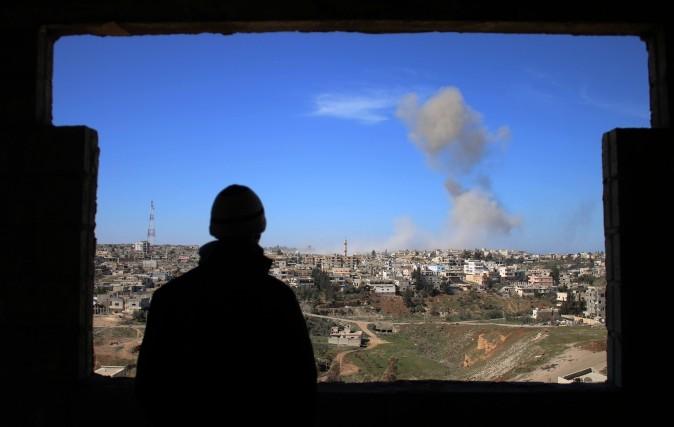 A man looks at smoke billowing after a reported car bomb explosion during clashes between rebel fighters and regime forces to take control of an area in the southern city of Daraa, Syria, on Feb. 20, 2017. (Mohamad Abazeed/AFP/Getty Images)