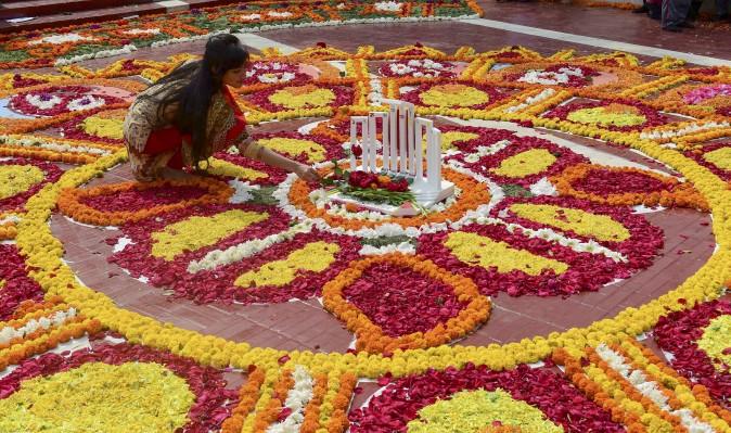 A Bangladeshi woman decorates the Bangladesh Central Language Martyrs' Memorial monument with flowers in homage to the martyrs of the 1952 Bengali Language Movement in Dhaka on Feb. 21, 2017. International Mother Language Day is celebrated each year on this day, marking 65 years since police officials fired at thousands of protesters at universities in then East Pakistan, who were demanding that Bengali be declared the state language. The deaths marked the start of a nearly two-decades-long struggle for the establishment of the state Bangladesh which was achieved when Indian troops were victorious in the 1971 independence war with Pakistan. (STR/AFP/Getty Images)