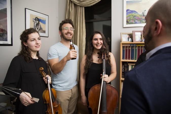 Sam Bodkin, CEO of Groupmuse, at a house concert with Rannveig Marta Sarc (L) and Clara Abel in Harlem, New York, on Feb. 17, 2017. (Samira Bouaou/Epoch Times)