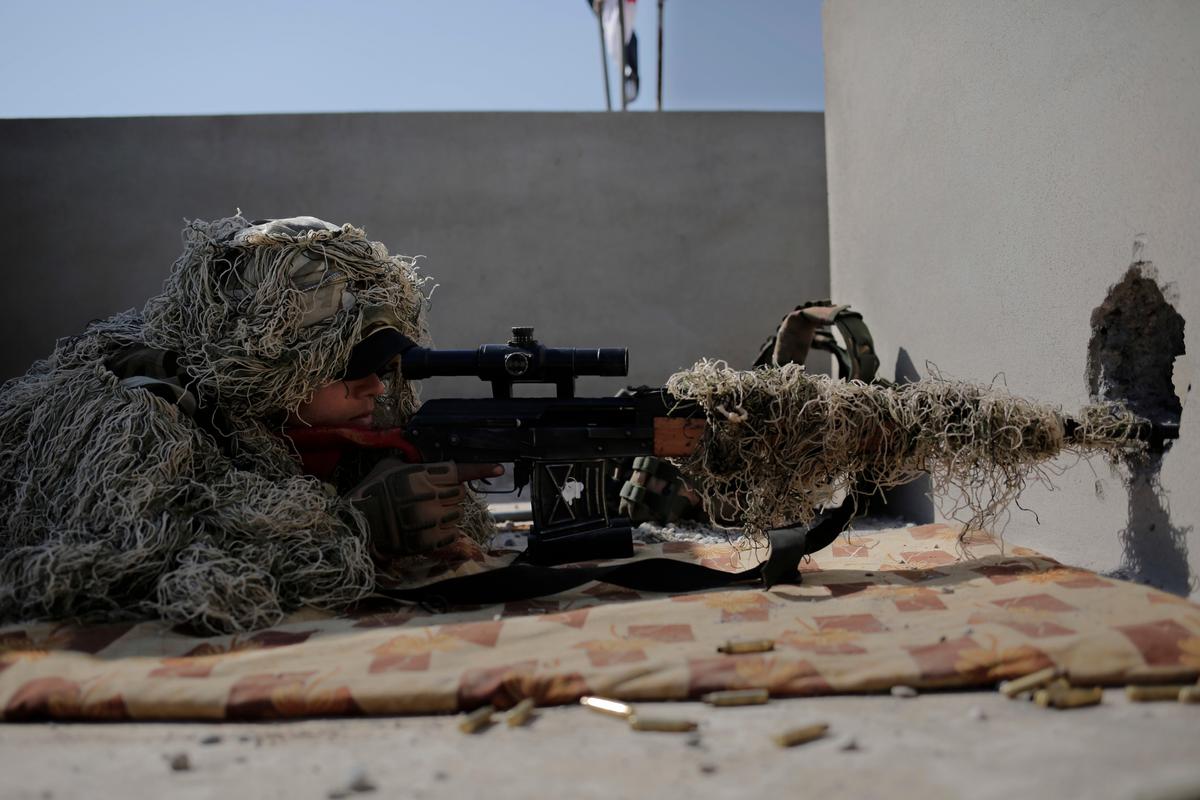 A sniper with the Iraqi federal police aims at an ISIS position from the rooftop of a house in the town of Abu Saif, on Feb. 22, 2017. (AP Photo/Bram Janssen)