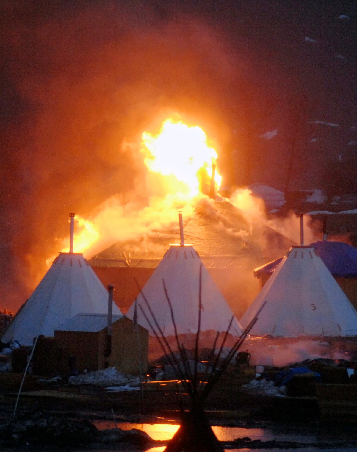 A fire on a building at a camp that has been home to demonstrators against the Dakota Access pipeline is seen after protesters set fire in Cannon Ball, N.D., on Feb. 22, 2017. (Mike Mccleary/The Bismarck Tribune via AP)