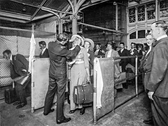An immigration inspector performs eye examinations on immigrants arriving at Ellis Island in New York in the early 1900s. (National Archives)