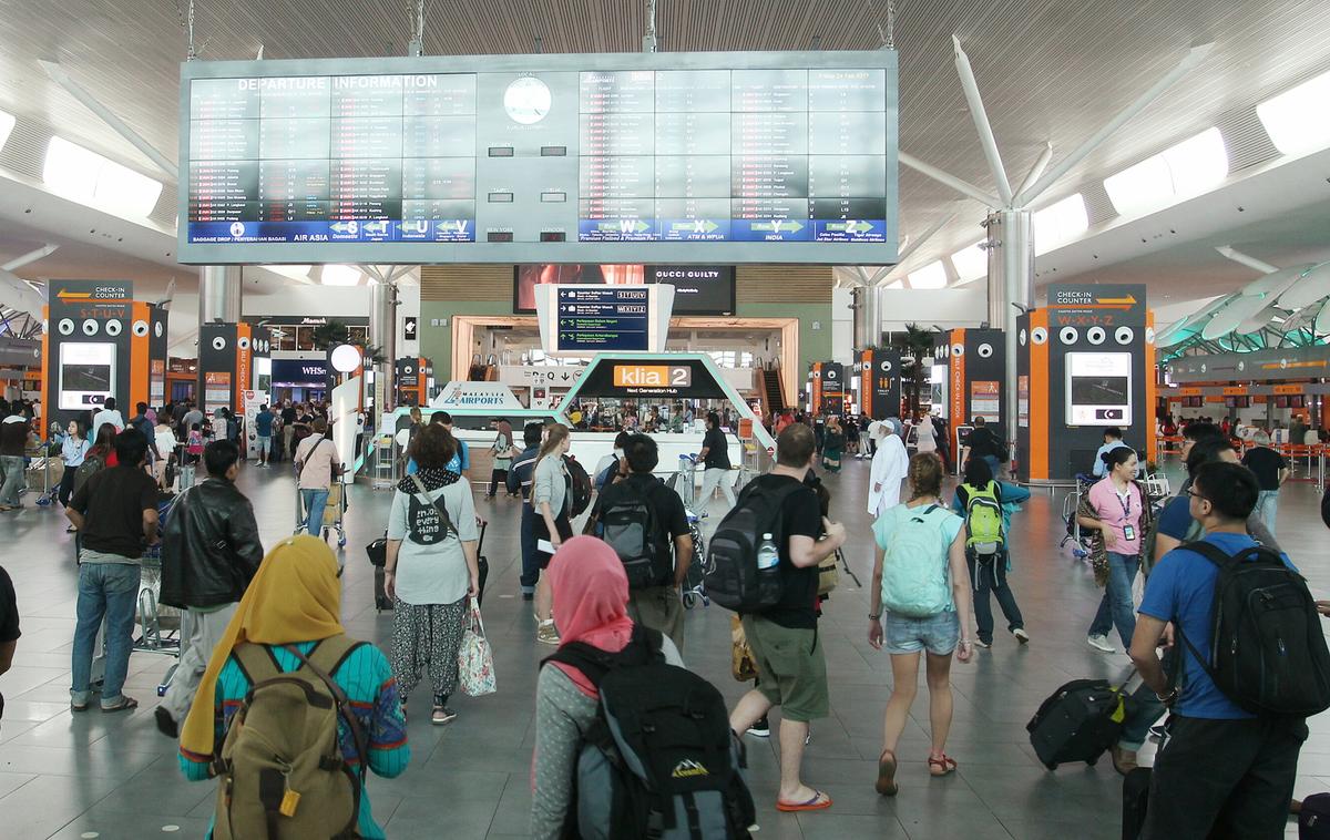 Passengers scan departure information at the Kuala Lumpur International Airport in Sepang, Malaysia on Feb. 24, 2017. (AP Photo)