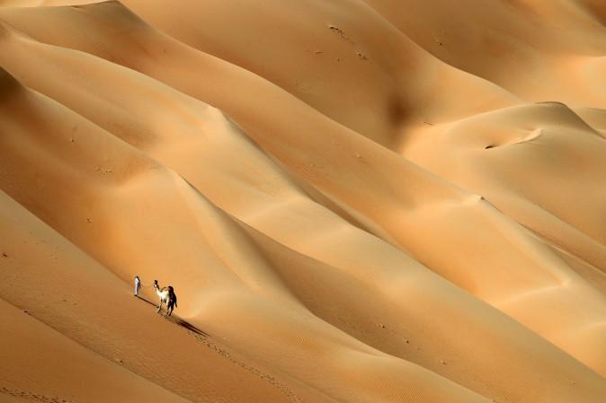 An Emirati man walks with his camels across the Hameem desert, some 170 kilometres west of the Gulf Emirate of Abu Dhabi, on Feb. 24. (KARIM SAHIB/AFP/Getty Images)
