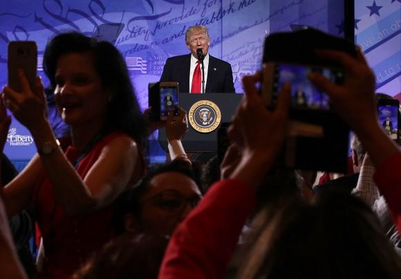 Attendees take pictures as President Donald Trump addresses the Conservative Political Action Conference at the Gaylord National Resort and Convention Center in National Harbor, Maryland on Feb. 24, 2017. (Alex Wong/Getty Images)
