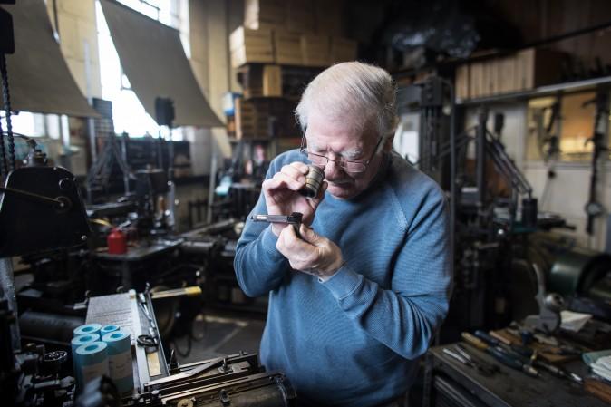 Printer Stan Lane checks the lettering produced by a composition caster at Gloucester Typesetting Services in Stonehouse, England, on Feb. 27, 2017. Stan Lane, who runs the last commercial Monotype business in Britain, started his career in 1954 as an apprentice aged 16. He is one of very few people still working in hot-metal lead type and is probably the last of the famous Monotype artisan print setters who still works for publishers and private customers. (Matt Cardy/Getty Images)