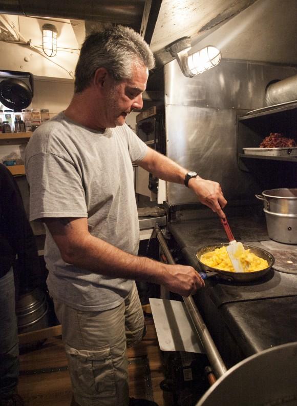 Chef James Tompkins cooking on "The Beast," a temperamental cast iron stove. (Channaly Philipp/Epoch Times)