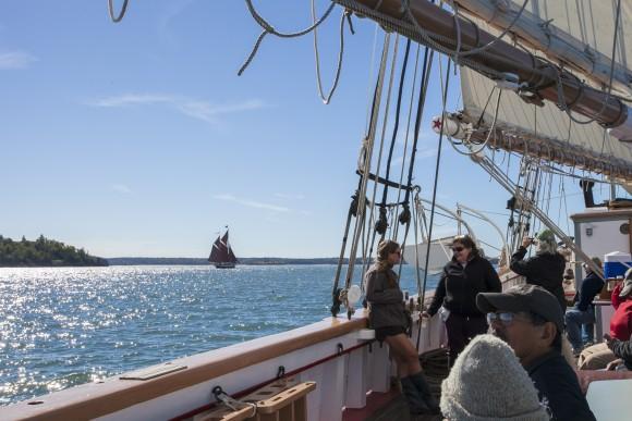 Passengers aboard the Victory Chimes while away the afternoon, as the The Angelique windjammer sails in the distance. (Channaly Philipp/Epoch Times)