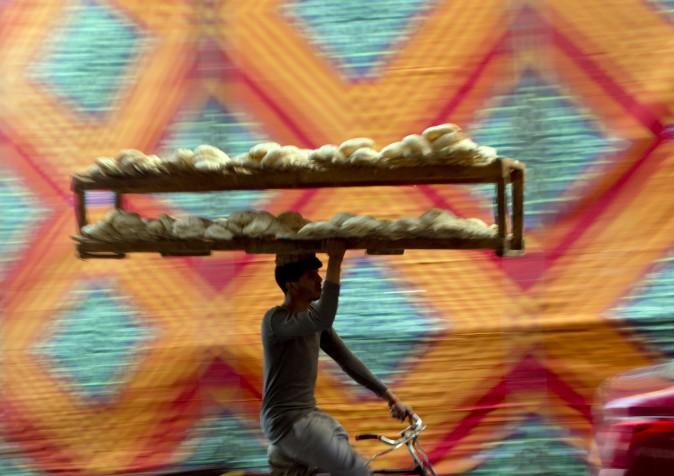 A vendor carries bread tray over his bicycle, in Cairo, Egypt, on March 3, 2017. (AP Photo/Amr Nabil)
