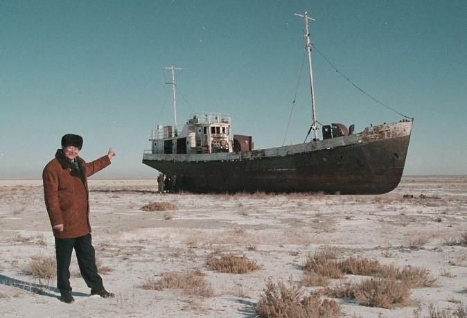 Aralsk's Mayor Alashbai Baimyrzayev points 23 March 1999 near the city of Kyzmet, a fishery on Aralsk's dry harbor at an abandoned fishermen ship in Aral Sea. (STRINGER/AFP/Getty Images)