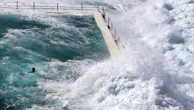 A swimmer at Bondi's ocean pool watches as a big wave pours into the pool at Bondi Beach in Sydney on March 6, 2017. (William West/AFP/Getty Images)