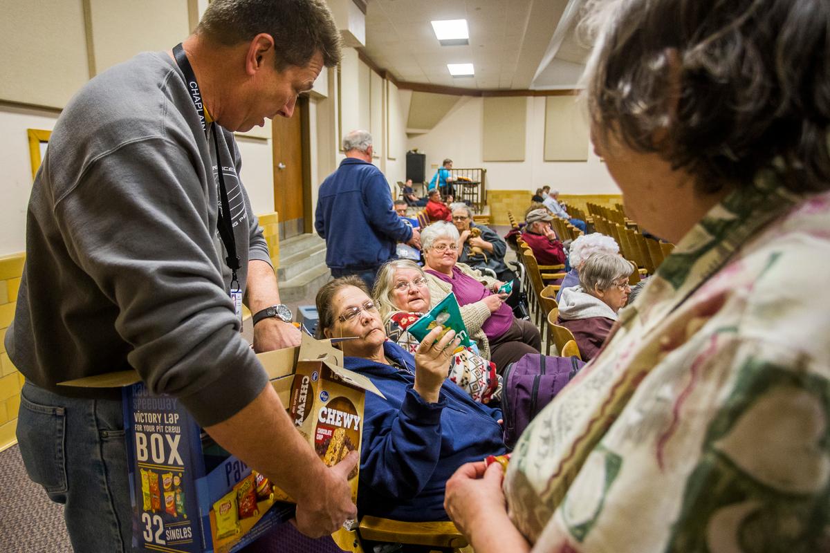 Southern Baptist Disaster Relief Chaplain Jeff Thompson passes bags of chips to (L-R) Suzanne Morgan, Carol Shaylor and Linda Nimmo inside an evacuation center at the Kansas State Fairgounds as a grassfire continues to rage north of Hutchinson, Kan., on March 6, 2017. (Katy Kildee/The Hutchinson News via AP)