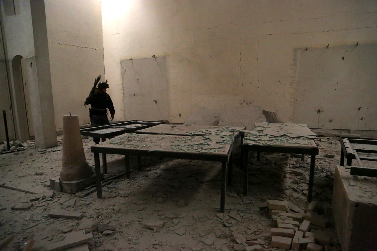 An Iraqi federal policeman inspects the inside of Mosul's heavily damaged museum. (AP Photo/Khalid Mohammed)
