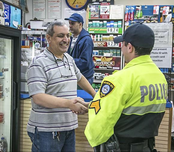 An Atlantic City Police Officer greets a manager of a deli on Atlantic Avenue as they make their rounds of visiting local stores in Atlantic City, N.J., on Feb. 15, 2017. (Benjamin Chasteen/Epoch Times)