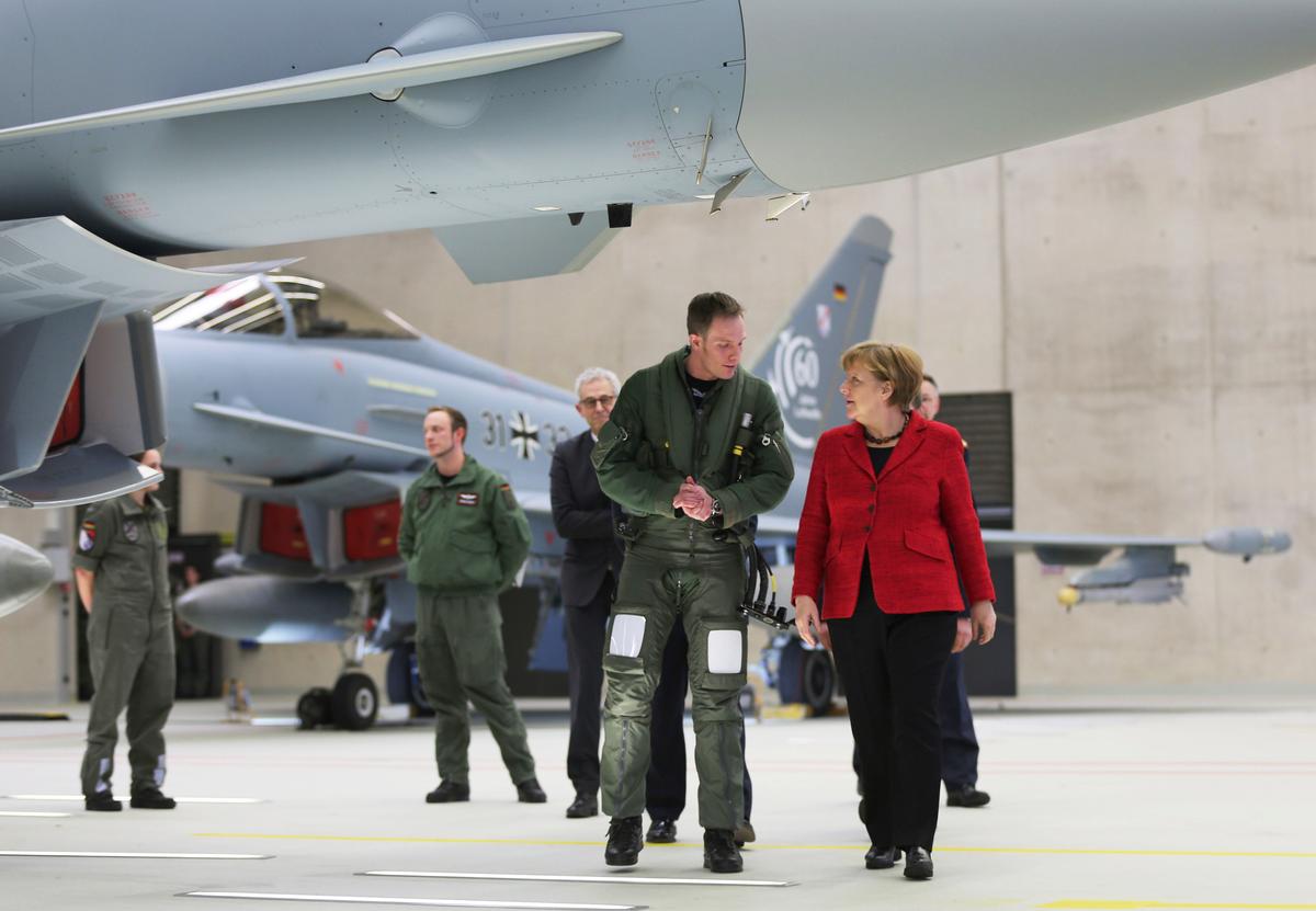 German Chancellor Angela Merkel speaks to pilot Patrick Betling (C) next to a Eurofighter in Noervenich, Germany on 21, 2016. (Oliver Berg//dpa via AP)