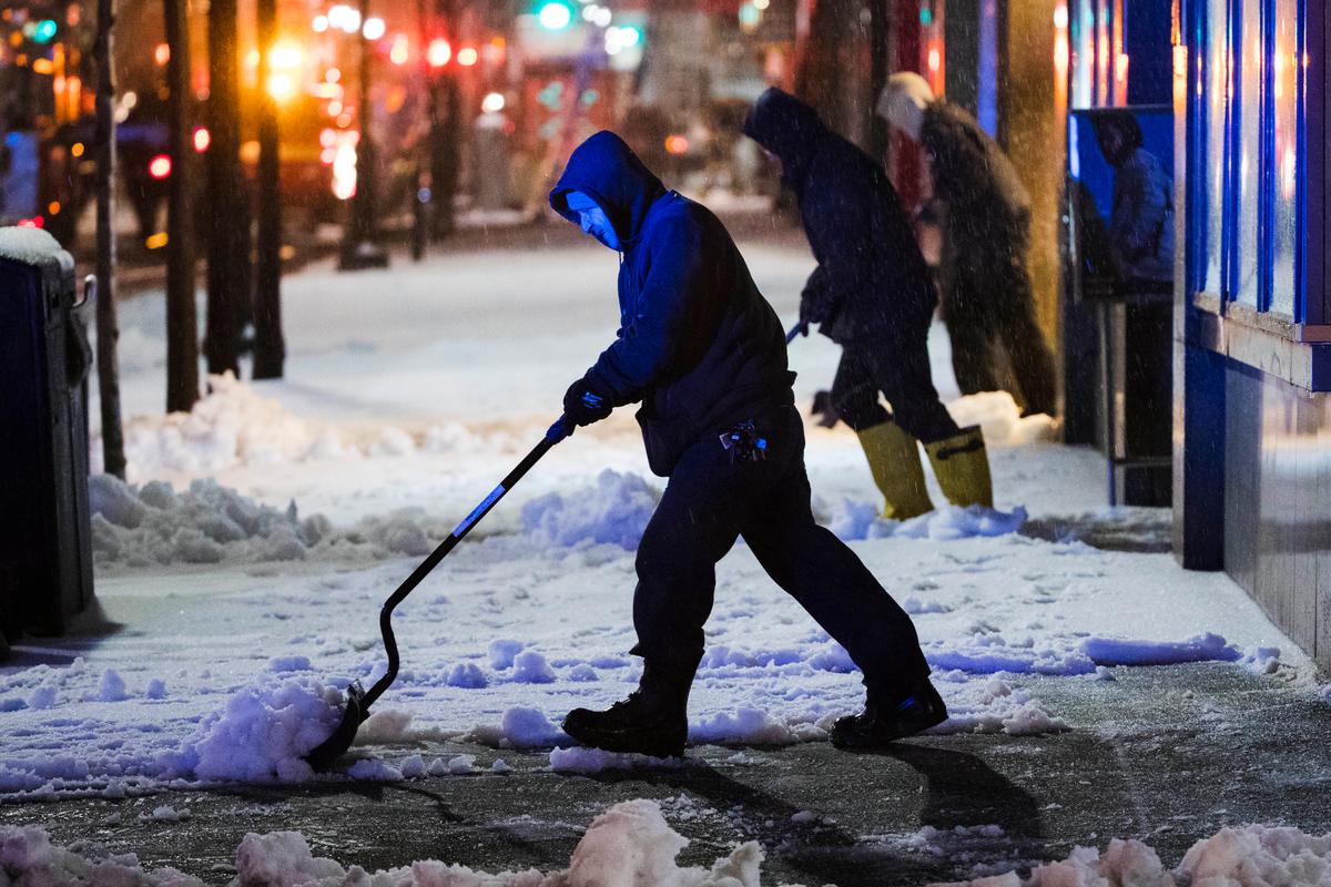 Workmen clear a sidewalk during a winter storm in Philadelphia on March 14, 2017. (AP Photo/Matt Rourke)