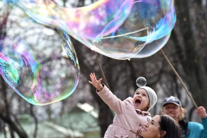 A girl is amused by soap bubbles made by a street artist in Kiev, Ukraine, on March 15, 2017. (Sergei Supinsky/AFP/Getty Images)