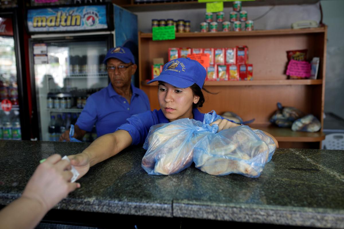 A saleswoman sells bread at a bakery in Caracas, Venezuela on March 17, 2017. (REUTERS/Marco Bello)