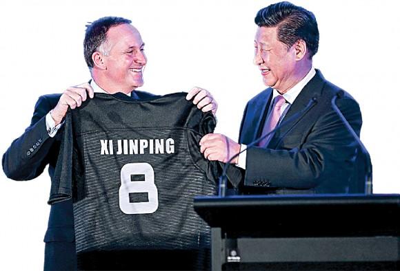 Former New Zealand Prime Minister John Key presents a rugby jersey to Chinese leader Xi Jinping in Wellington, New Zealand, on Nov. 20, 2014. China has become the biggest buyer of New Zealand farmlands, and Shanghai Pengxin is now New Zealand's third-largest dairy producer. (Hagen Hopkins/Getty Images)