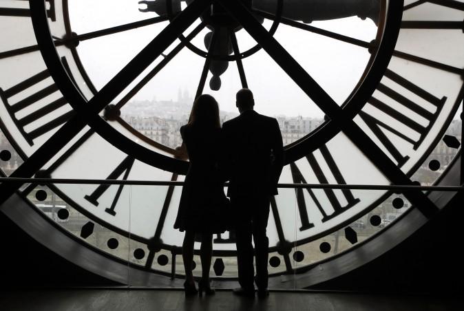 Britain's Prince William, Duke of Cambridge, and his wife Britain's Kate, Duchess of Cambridge, look at the Seine river through a giant clock at the Musee d'Orsay museum -the former Gare d'Orsay train station- during their visit to the museum on March 18. (Francois Guillot/Pool Photo via AP)