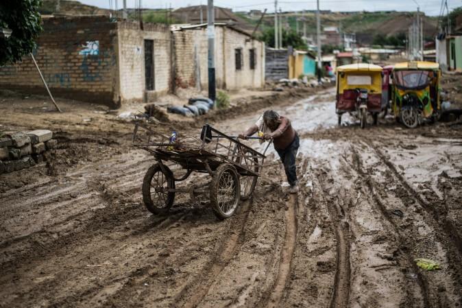 A local resident pushes his cart through the mud after flooding caused by recent rains, in the province of Paita in Piura, Peru, on March 24. The El Nino climate phenomenon is causing muddy rivers to overflow along the entire Peruvian coast, isolating communities and neighborhoods. (ERNESTO BENAVIDES/AFP/Getty Images)