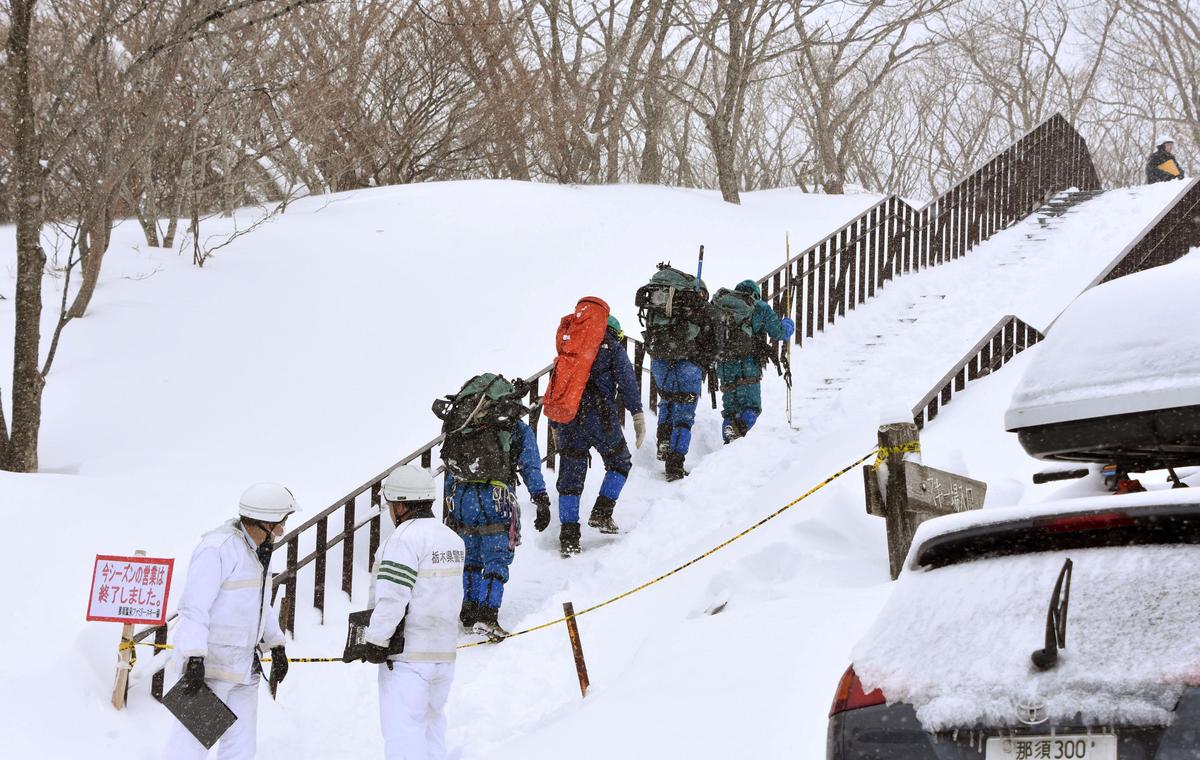 Rescue workers climb toward a mountain for searching missing people after an avalanche near a ski resort in Nasu town, north of Tokyo. (Kyodo/via REUTERS)