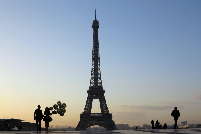 A young couple who were just recently married walk at sunrise on the Esplanade du Trocadero near the Eiffel tower in Paris on March 28. (LUDOVIC MARIN/AFP/Getty Images)