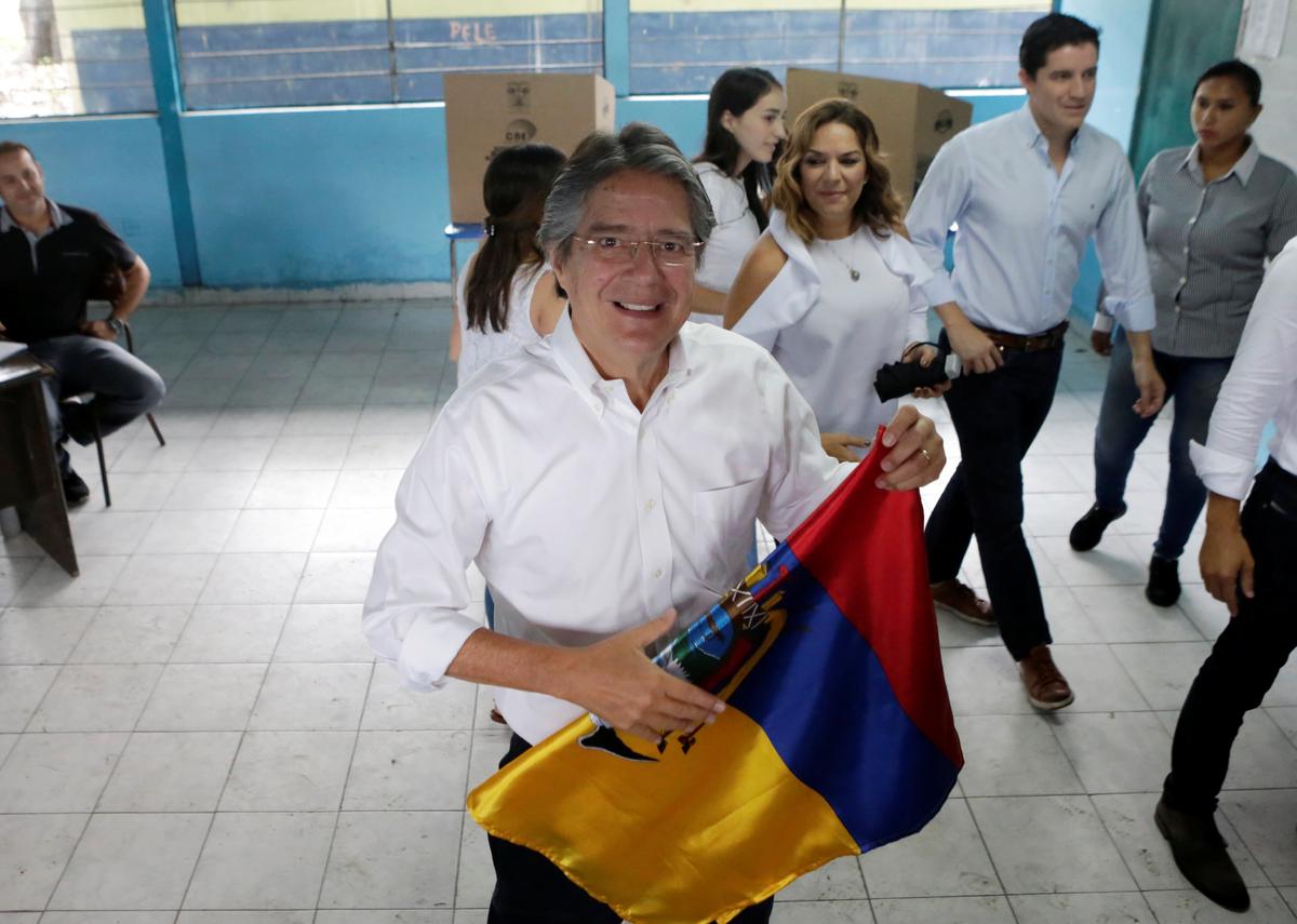 Ecuadorean presidential candidate Guillermo Lasso folds a national flag after casting his vote during the presidential election in Guayaquil, Ecuador on April 2, 2017. (REUTERS/Henry Romero)