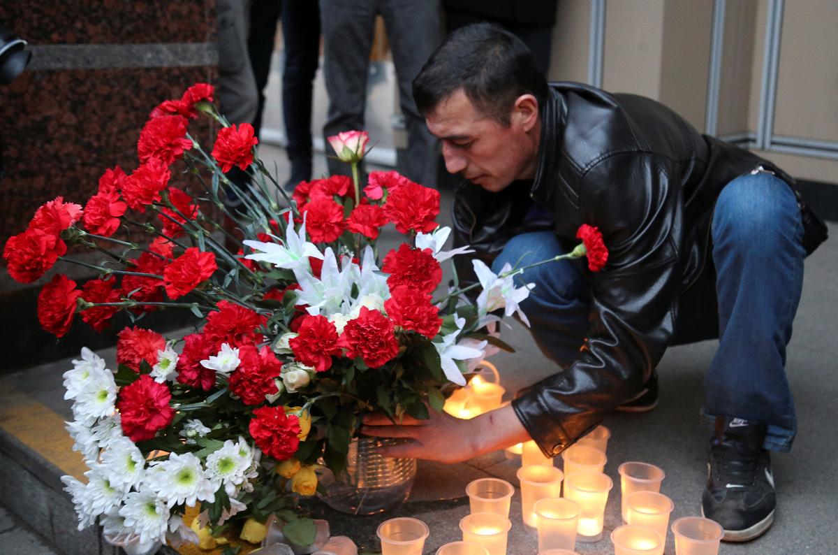 A man leaves flowers during a memorial service for victims of a blast in St.Petersburg metro, outside Sennaya Ploshchad metro station in St. Petersburg, Russia on April 3, 2017. (REUTERS/Igor Russak)