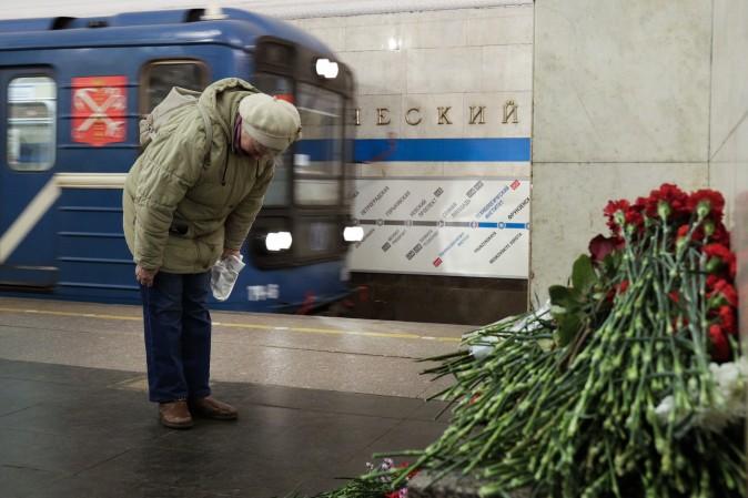 A woman pays her respects at a makeshift memorial at Tekhnologichesky Institute subway station in St. Petersburg, Russia, on April 4, the day after a bomb blew up a subway car, killing at least 14 people. (AP Photo/Dmitri Lovetsky)