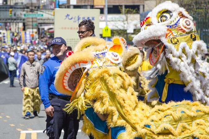 Police officers with a lion dance team at a parade in Flushing, New York, on April 23, 2017, to commemorate the 18th anniversary of the April 25th peaceful appeal of 10,000 Falun Gong practitioners in Beijing. (Samira Bouaou/The Epoch Times)
