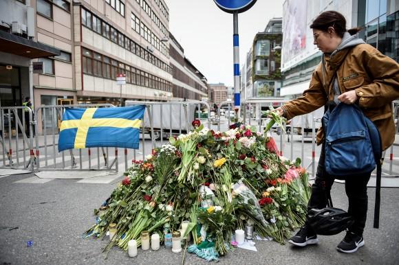 People gather at a police cordon near the crime scene in central Stockholm on April 08, 2017, the day after a hijacked beer truck plowed into pedestrians on Drottninggatan and crashed into Ahlens department store, killing four people, injuring 15 others. (TT News Agency/Noella Johansson/via REUTERS)