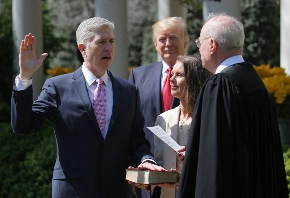 Judge Neil Gorsuch (L) is sworn in as an associate justice of the Supreme Court by Supreme Court Associate Justice Anthony Kennedy (R), as U.S. President Donald J. Trump (C) watches with Louise Gorsuch in the Rose Garden of the White House in Washington on April 10, 2017. (REUTERS/Carlos Barria)