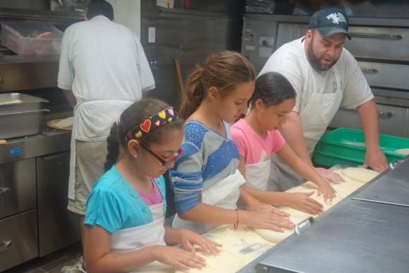 A summer enrichment program through Housing Families Inc. had staff of Pisa Pizza in Malden, Mass. teach children how to make pizza. (Housing Families, Inc.)