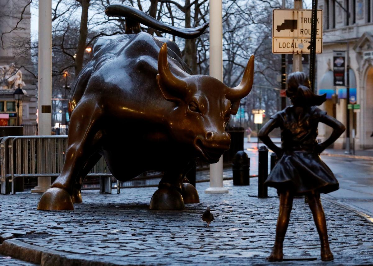 A statue of a girl facing the Wall St. Bull is seen, as part of a campaign by U.S. fund manager State Street to push companies to put women on their boards, in the financial district in New York on March 7, 2017. (REUTERS/Brendan McDermid)