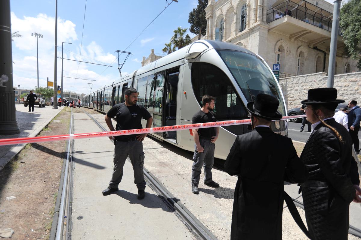 Israeli policemen block a road where the light train passes following a stabbing attack just outside Jerusalem's Old City, according to Israeli police on April 14, 2017. (REUTERS/Ammar Awad)