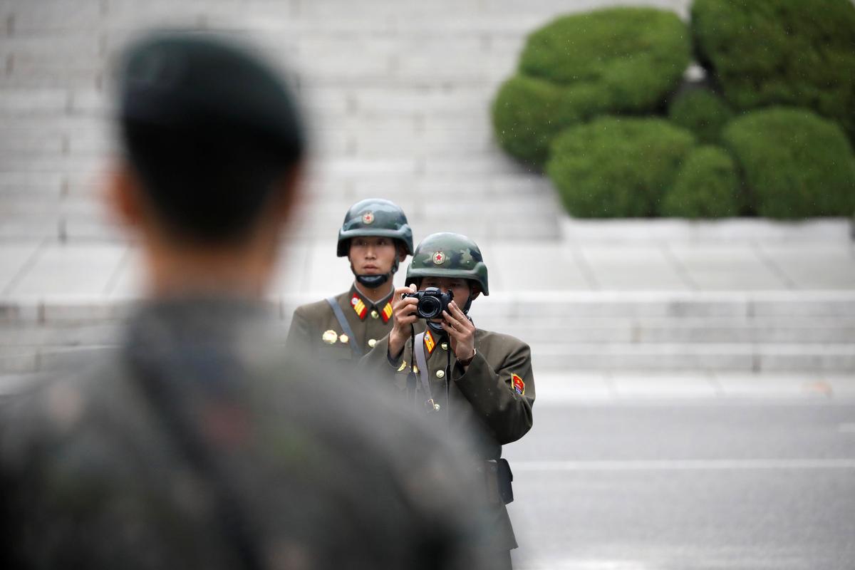 A North Korean soldier takes photographs as U.S. Vice President Mike Pence arrives at the truce village of Panmunjom, South Korea on April 17, 2017. (REUTERS/Kim Hong-Ji)