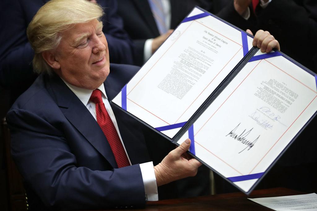 President Donald Trump holds up the Veterans Choice Program And Improvement Act after signing it in the Roosevelt Room at the White House in Washington on April 19, 2017. (Chip Somodevilla/Getty Images)